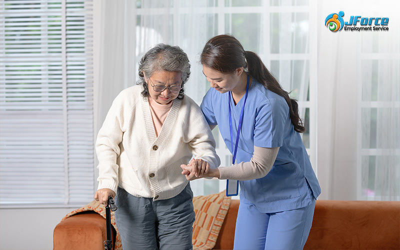 Caregiver supporting elderly patient as she walks