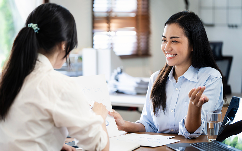 Employer interviewing maid agency agent before hiring domestic helper.