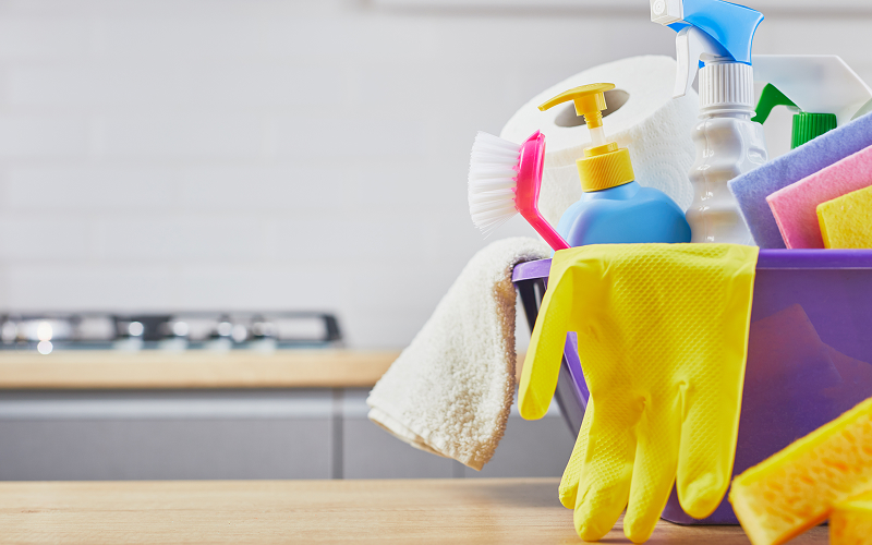 Bucket filled with cleaning supplies and yellow rubber gloves.